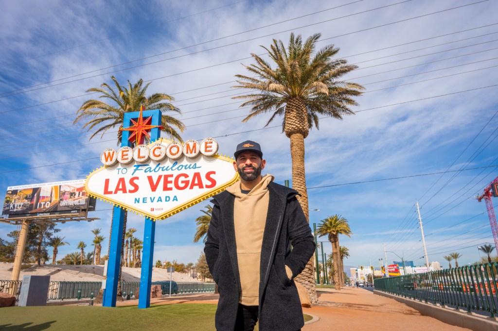 José Bautista in front of the Welcome to Las Vegas sign 