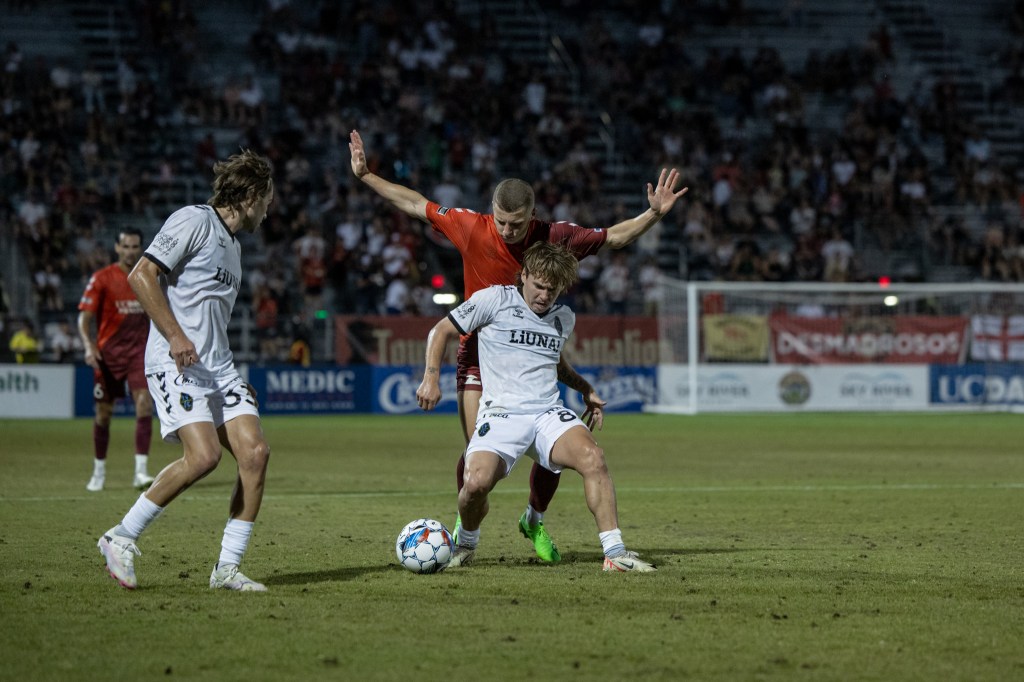 Las Vegas Lights forward Coleman Gannon shielding the ball away from a Sacramento Republic player