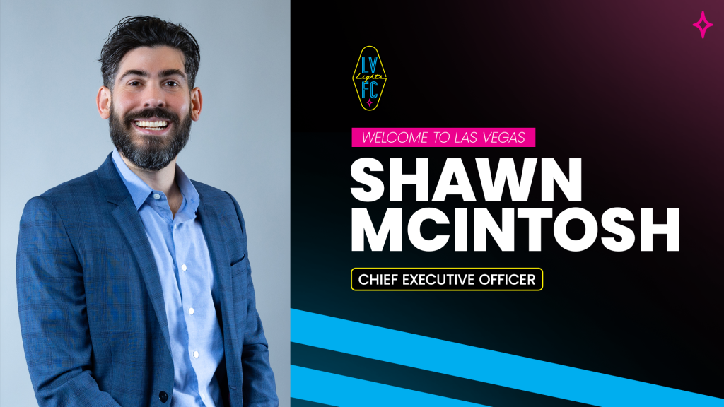 New Las Vegas Lights FC CEO Shawn McIntosh. Man with a dark beard and slicked back hair wearing a dark blue suit jacket and light blue button-up shirt
